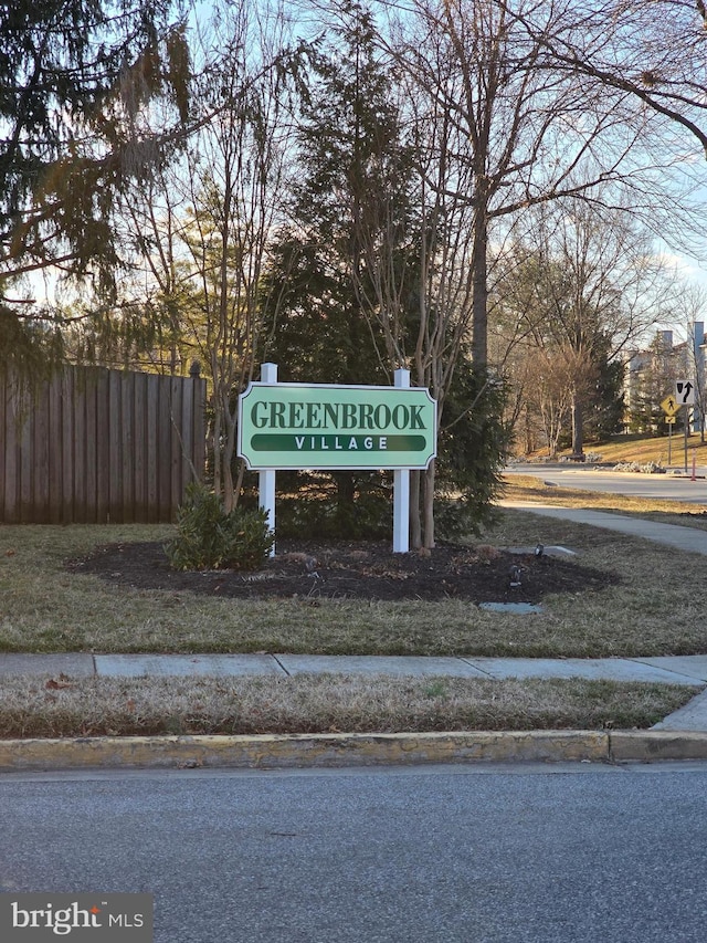 community / neighborhood sign with fence