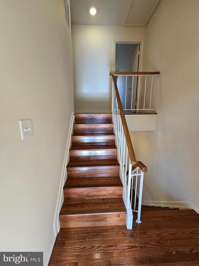 stairs featuring wood finished floors and baseboards