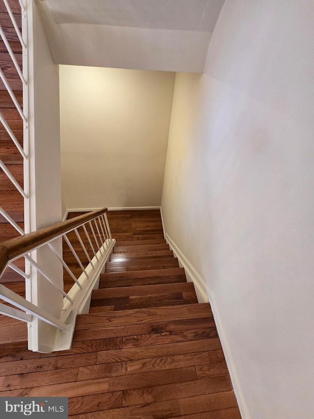 stairway featuring baseboards and wood finished floors