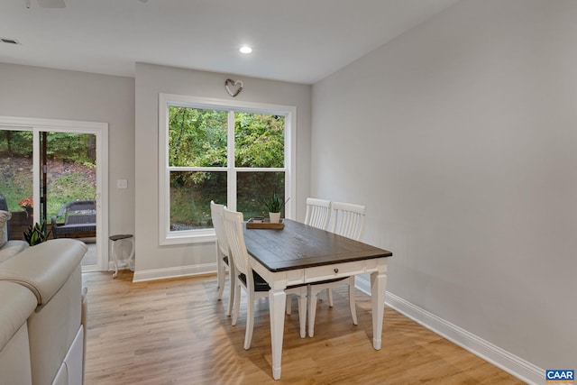 dining area with light wood finished floors, plenty of natural light, and baseboards