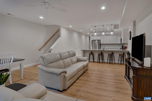 living room featuring stairs, recessed lighting, visible vents, and light wood-style floors