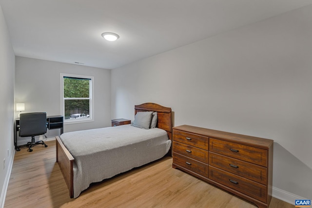 bedroom featuring baseboards, visible vents, and light wood-style floors