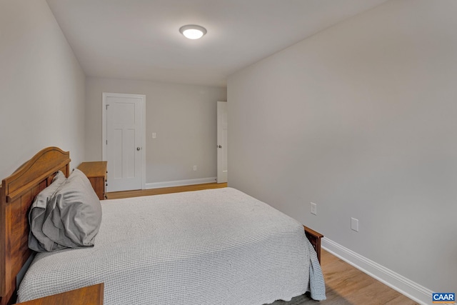 bedroom featuring baseboards and wood finished floors