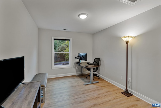 office space with light wood finished floors, visible vents, and baseboards