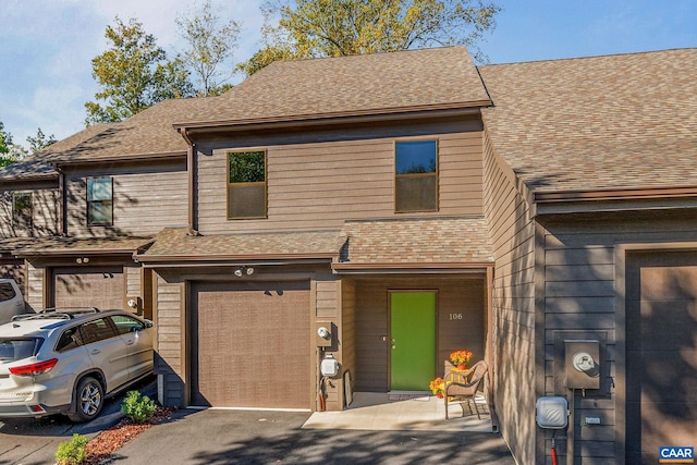 townhome / multi-family property featuring a garage and roof with shingles