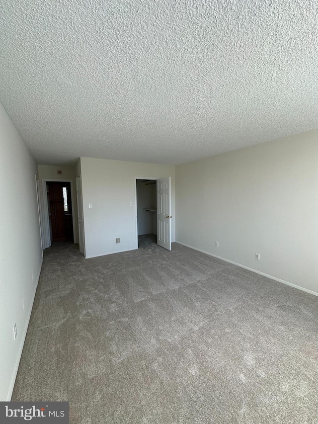 interior space with a textured ceiling, a closet, baseboards, and light colored carpet