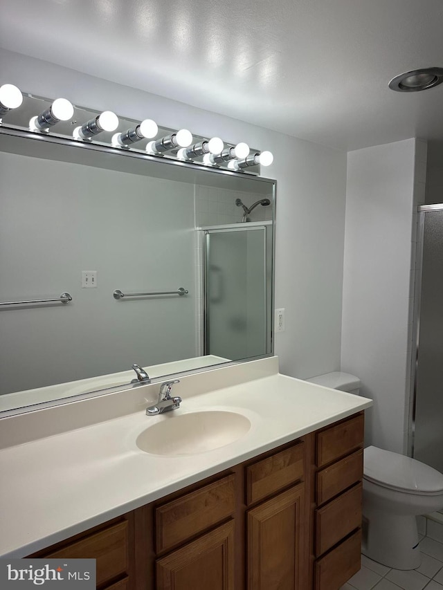 bathroom featuring vanity, a shower stall, and toilet