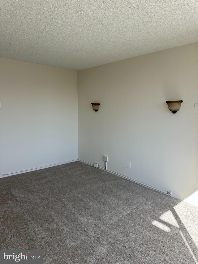 carpeted empty room with a textured ceiling