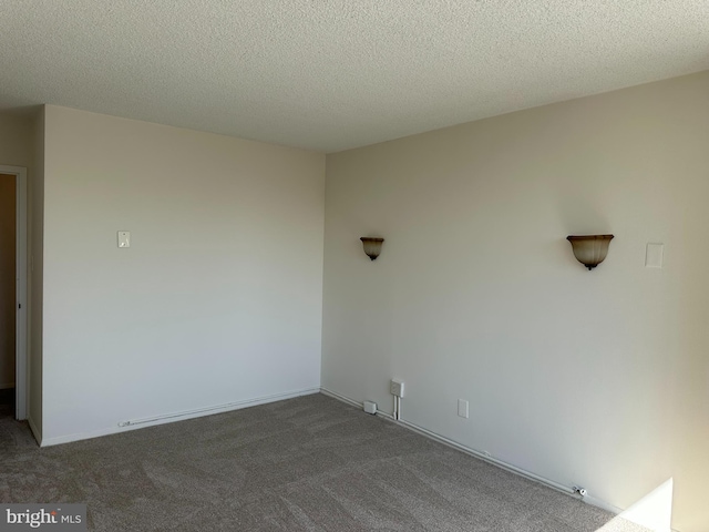 empty room with a textured ceiling and carpet flooring