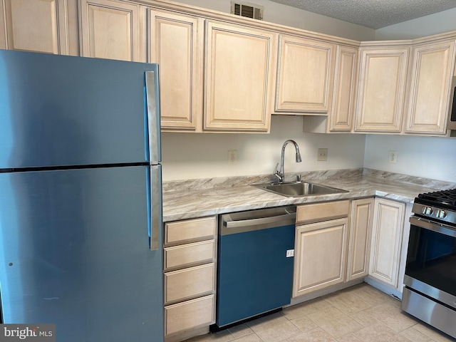 kitchen featuring a textured ceiling, appliances with stainless steel finishes, a sink, and visible vents