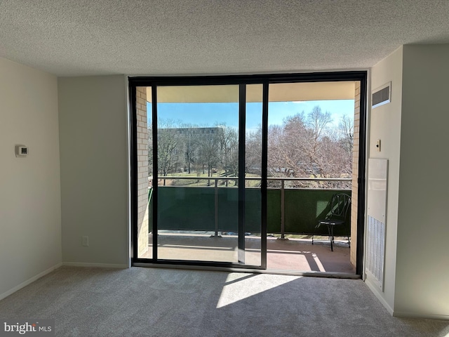 doorway featuring carpet floors, visible vents, a wall of windows, and a textured ceiling