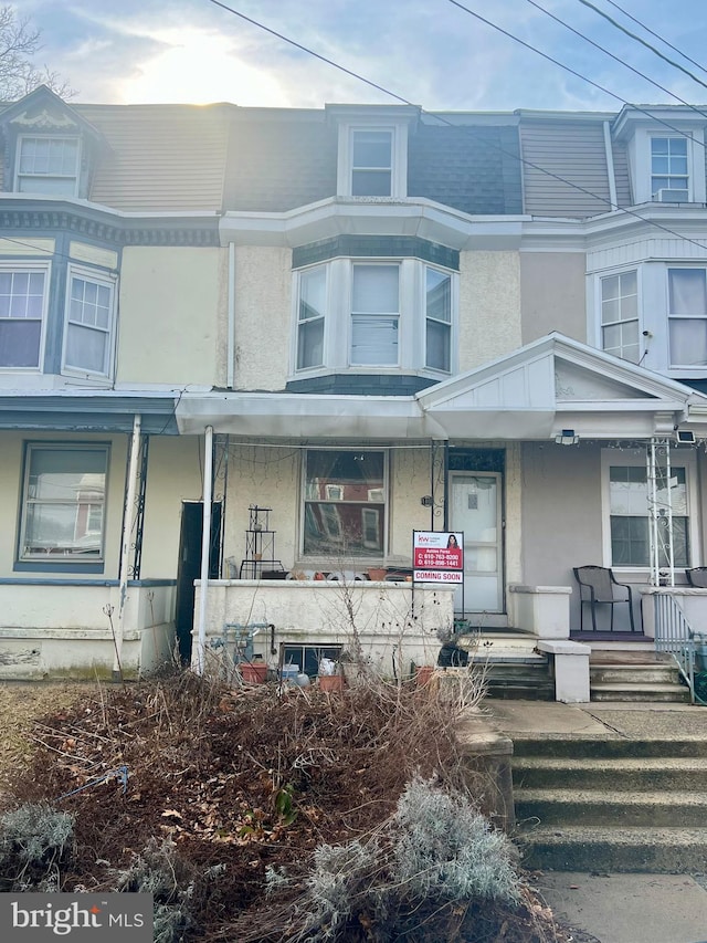 view of property with a porch and stucco siding