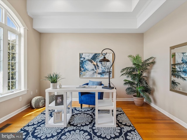 office area with baseboards, crown molding, visible vents, and wood finished floors