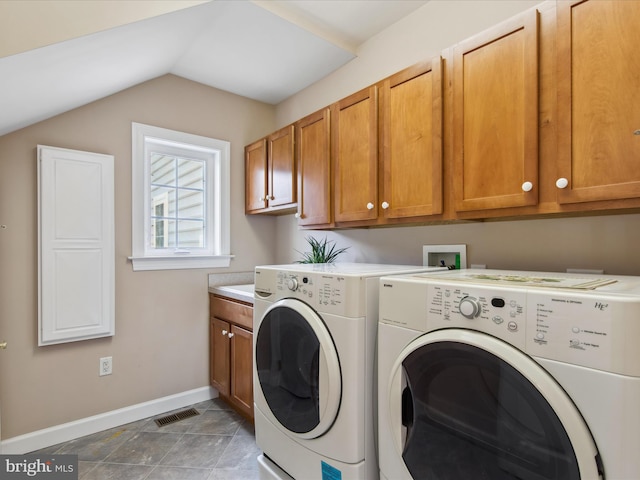 washroom featuring visible vents, washing machine and dryer, cabinet space, and baseboards