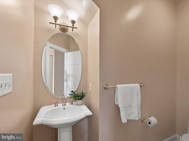 bathroom featuring a notable chandelier and a sink