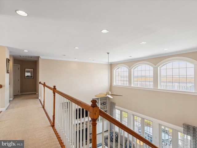 corridor with recessed lighting, light colored carpet, crown molding, and an upstairs landing