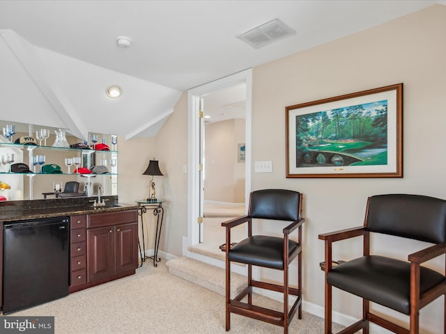 bar with light colored carpet, refrigerator, a sink, visible vents, and wet bar