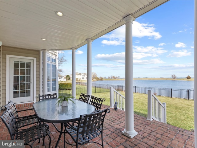 view of patio / terrace featuring a water view, a fenced backyard, and outdoor dining area