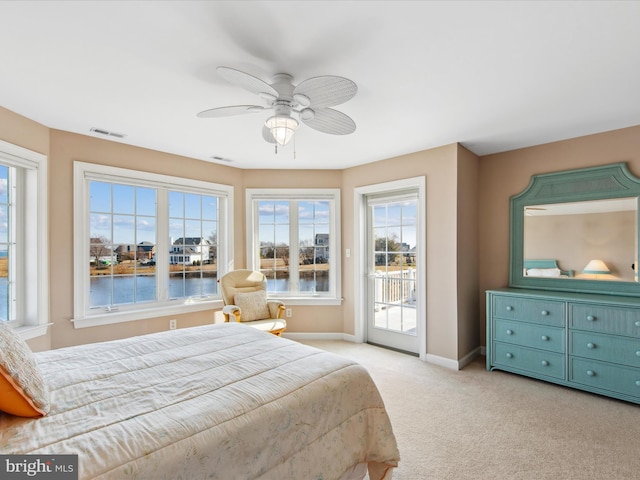 bedroom with visible vents, a water view, light carpet, access to outside, and baseboards