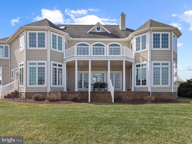 back of house featuring a balcony, a chimney, crawl space, a yard, and french doors