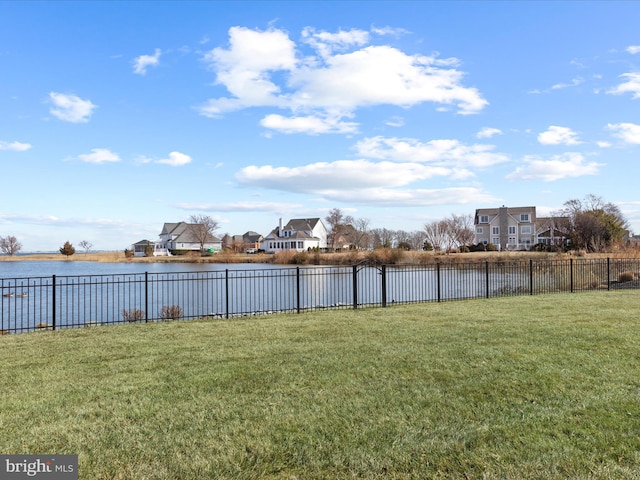 view of yard featuring a water view and fence