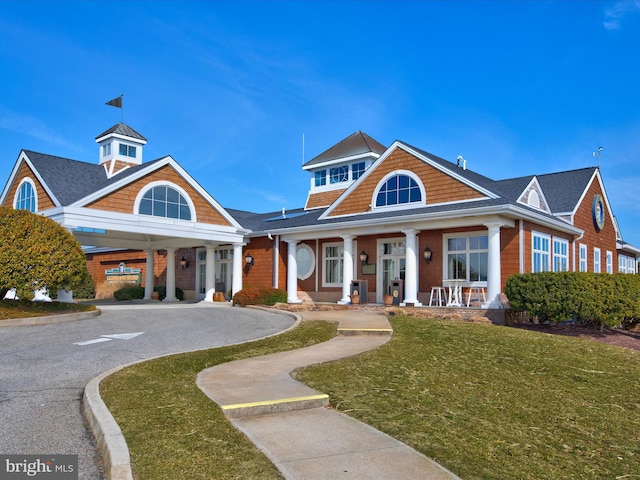 view of front facade with a front yard, covered porch, and driveway