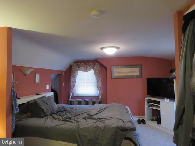 bedroom with radiator, light carpet, baseboards, and lofted ceiling