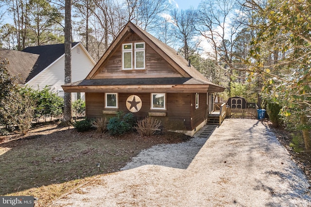 rustic home with gravel driveway and an outbuilding