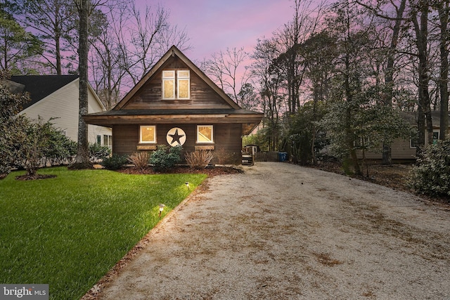 rustic home featuring driveway and a lawn