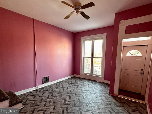 entryway with baseboards, visible vents, and ceiling fan