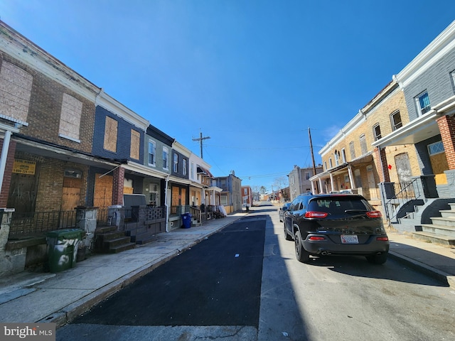 view of road with sidewalks, a residential view, and curbs