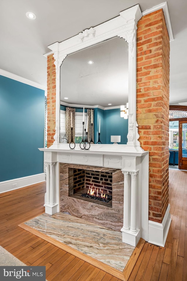 4502 Roland Ave, Baltimore, MD 21210 - detailed view of baseboards, wood finished floors, a warm lit fireplace, crown molding, and recessed lighting
