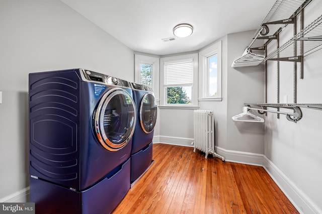 4502 Roland Ave, Baltimore, MD 21210 - laundry area featuring radiator heating unit, washing machine and dryer, baseboards, and hardwood / wood-style floors