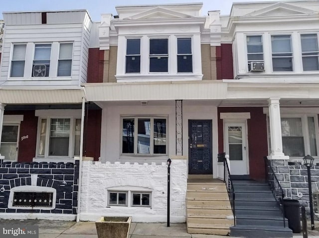 townhome / multi-family property featuring stone siding and cooling unit