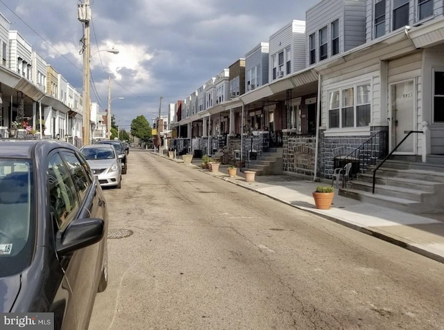 view of road featuring a residential view, sidewalks, and street lights