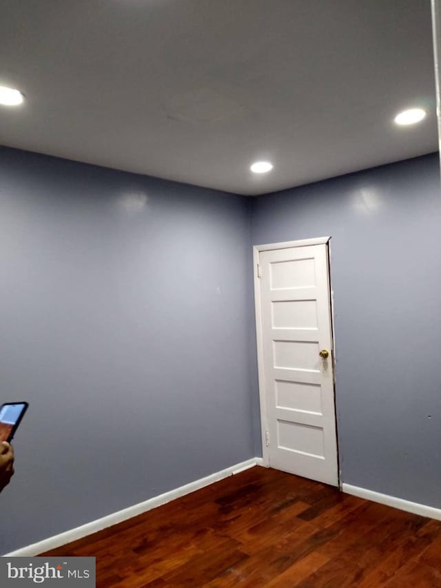 spare room with dark wood-style floors, recessed lighting, and baseboards