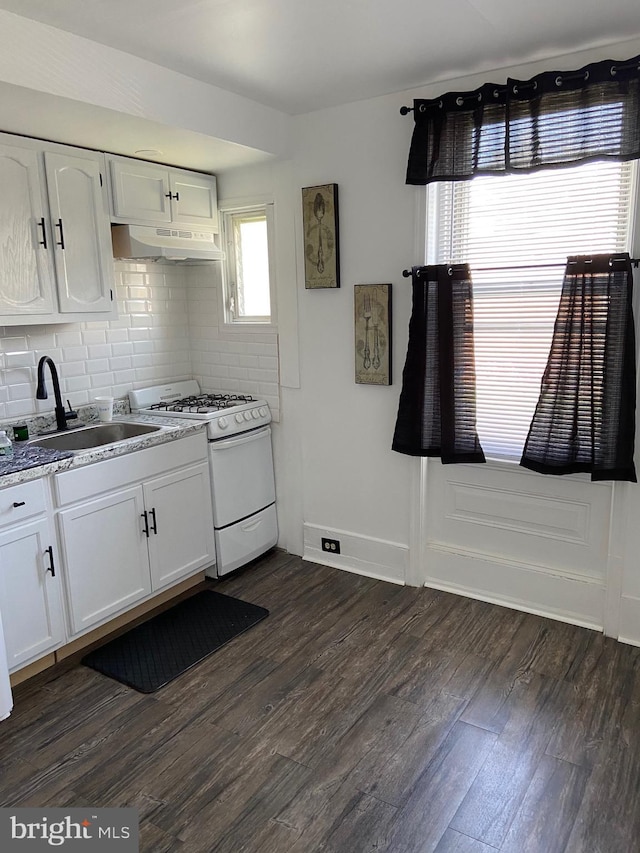 kitchen featuring dark wood-type flooring, a sink, under cabinet range hood, and white gas range