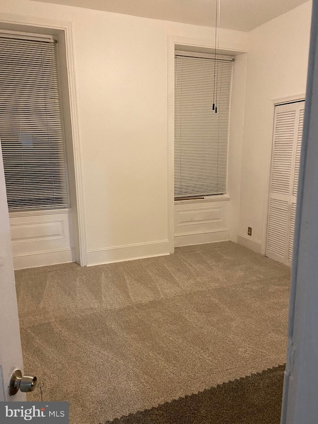 unfurnished room featuring carpet floors and baseboards