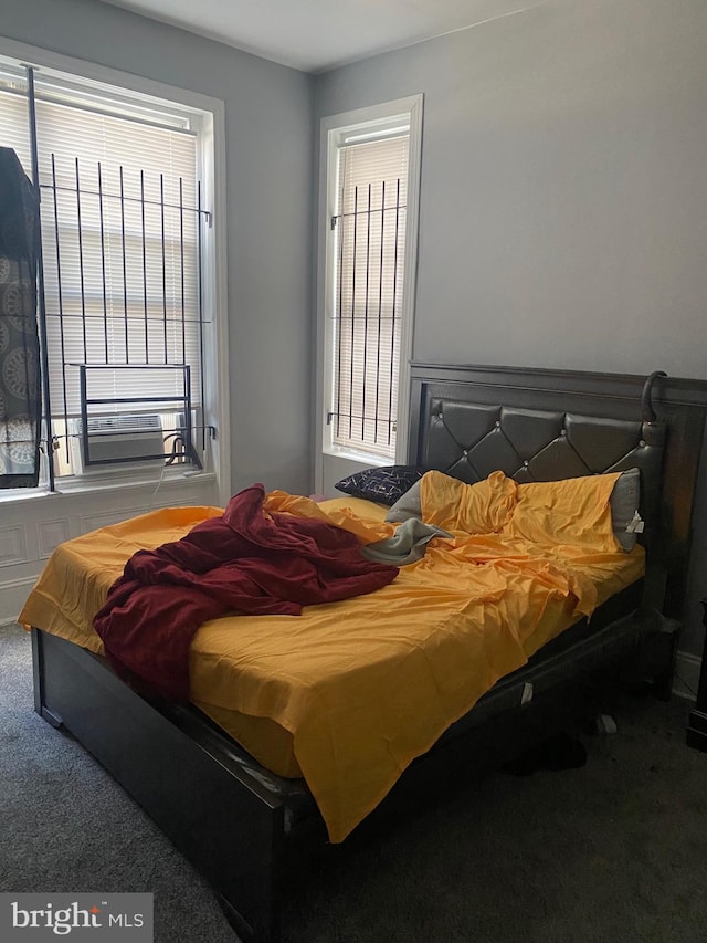 bedroom featuring cooling unit, multiple windows, and carpet flooring