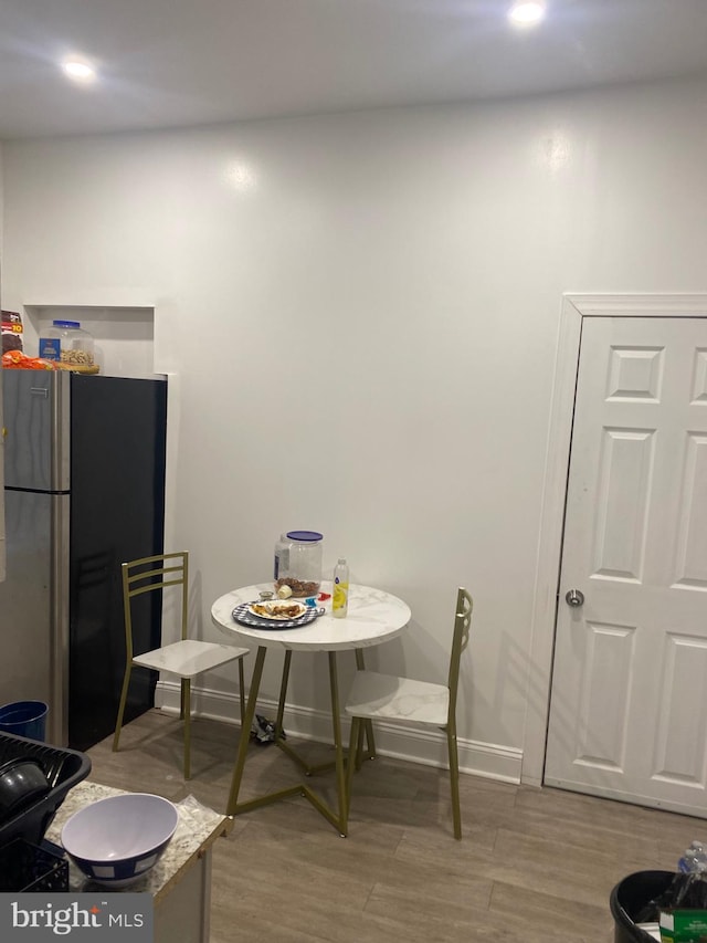 dining space with wood finished floors and baseboards