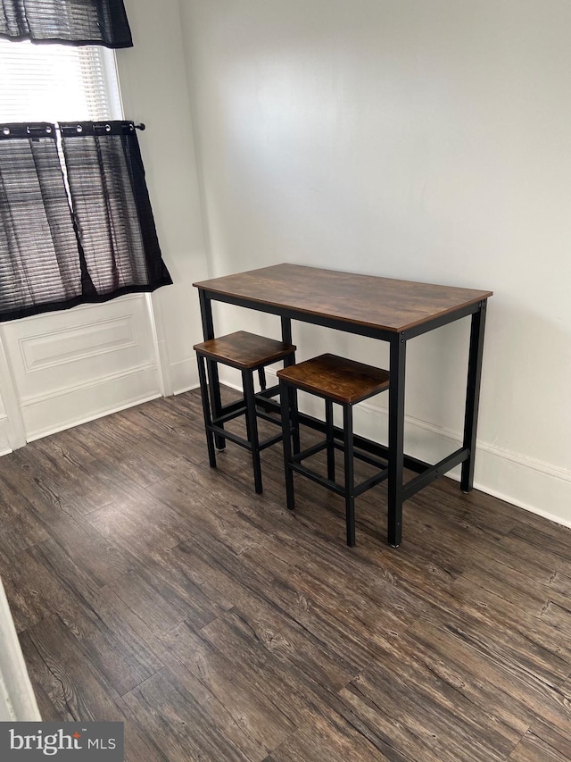 unfurnished dining area with baseboards and wood finished floors