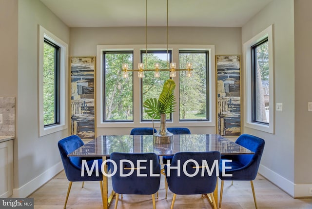 dining area with a notable chandelier, baseboards, and wood finished floors