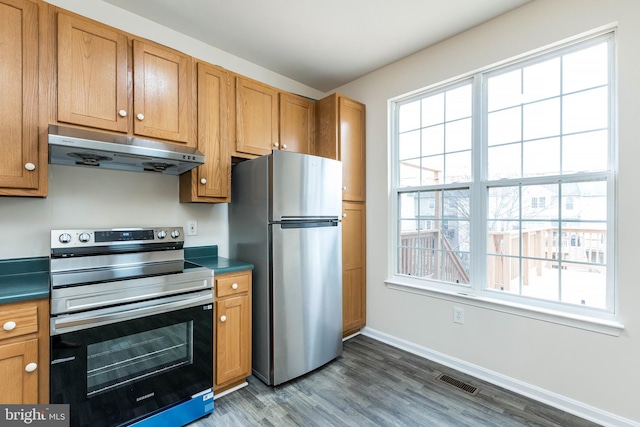 kitchen with dark countertops, visible vents, under cabinet range hood, and stainless steel appliances