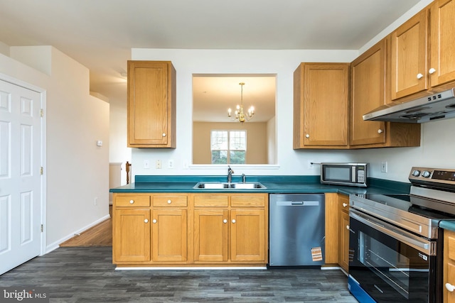 kitchen featuring a sink, stainless steel appliances, dark countertops, and under cabinet range hood