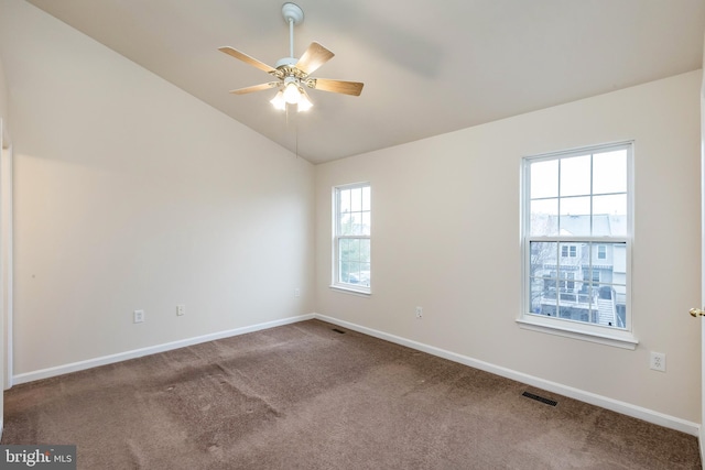 carpeted empty room featuring lofted ceiling, baseboards, and ceiling fan