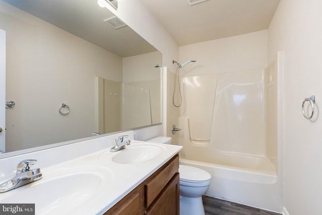 bathroom with double vanity, toilet, bathing tub / shower combination, and a sink