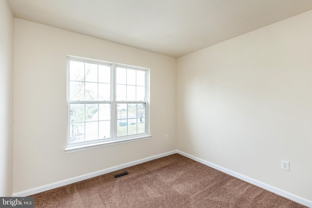 carpeted empty room featuring baseboards and visible vents