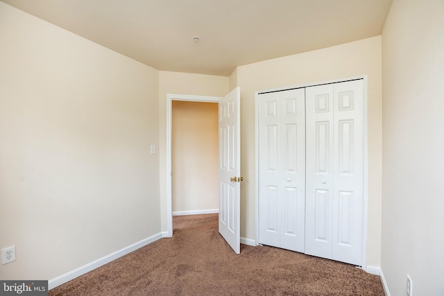 unfurnished bedroom featuring a closet, carpet flooring, and baseboards