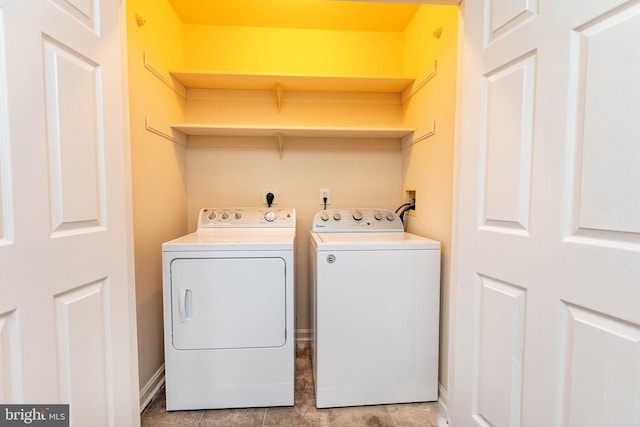 washroom with baseboards, washing machine and dryer, and laundry area