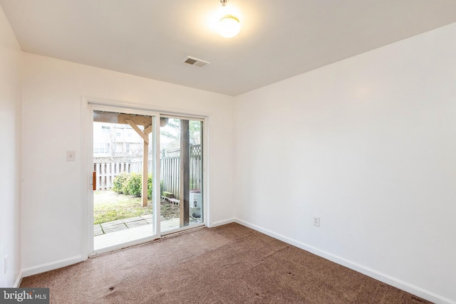 carpeted spare room featuring baseboards and visible vents